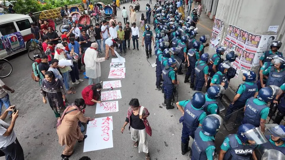 Police turn away as protesters place defiant posters in front of them. Kodom Foara (fountain). 